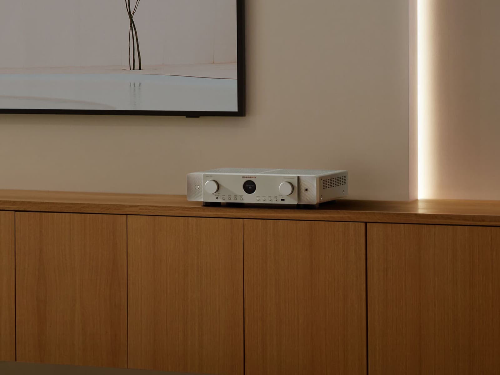 Marantz stereo amplifier on a wooden sideboard in a warmly lit living room.