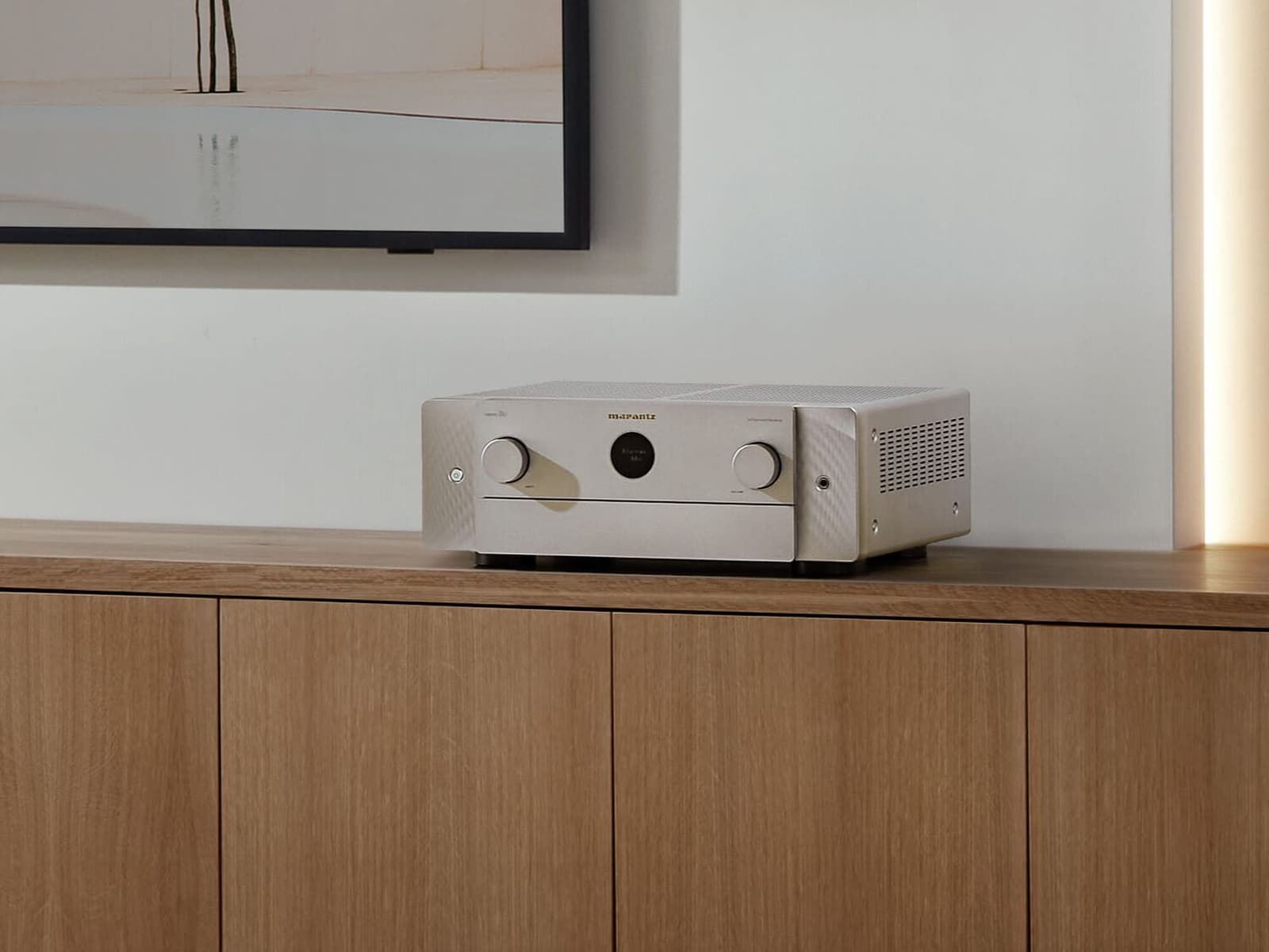 Marantz AV receiver in Silver-Gold on an oak sideboard below a wall-mounted screen.